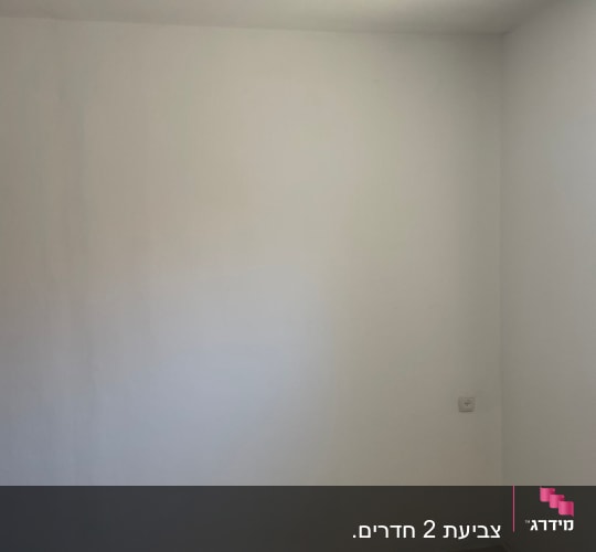 קיר צבוע בלבן עם שקע חשמל ותקרה עם נורה